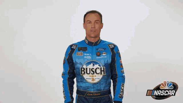 a man wearing a blue busch jacket stands in front of a white background