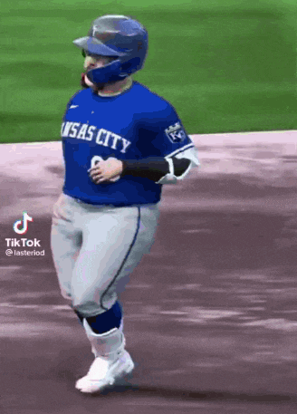a baseball player wearing a blue kansas city jersey is running on the field .