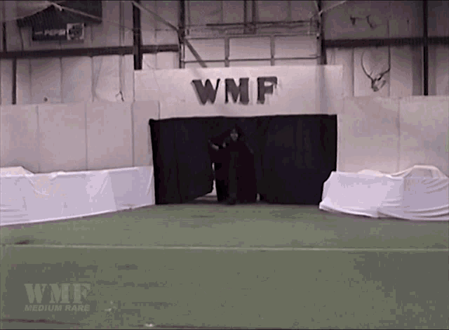 a man stands in front of a sign that says wmf