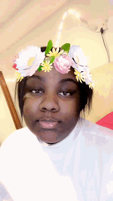a woman wearing a flower crown looks at the camera