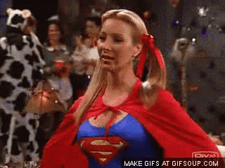 a woman in a superman costume is standing in front of a crowd of people