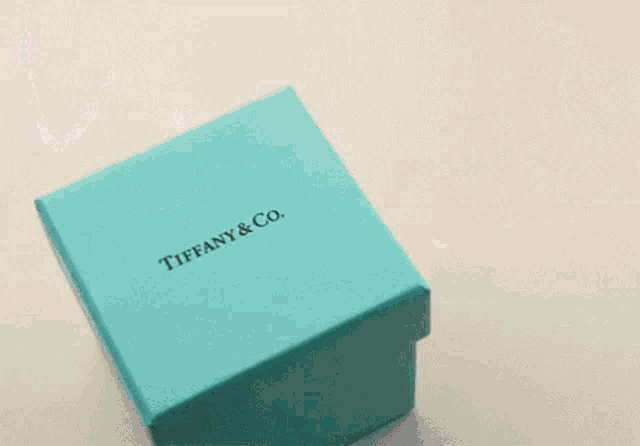 a blue box from tiffany & co. with pink hearts coming out of it