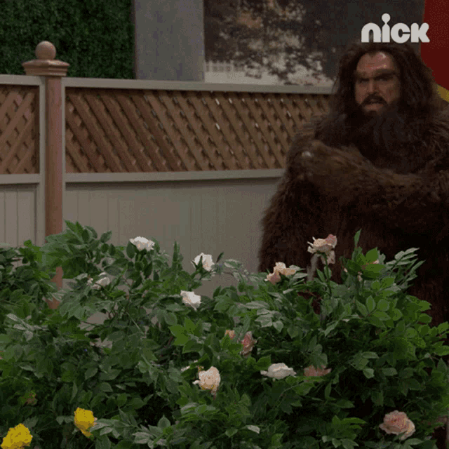 a man in a bigfoot costume stands in front of a fence with nick written on the bottom