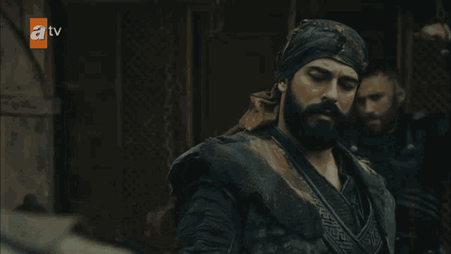 a tv screen shows a man with a beard wearing a bandana