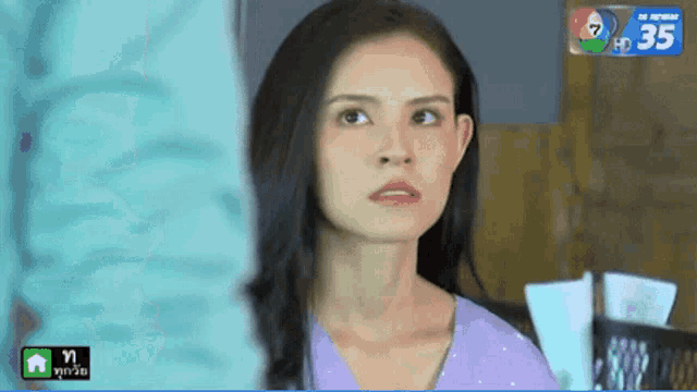 a woman in a purple shirt is looking at something