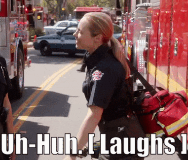 a woman in a firefighter uniform says uh-huh i laughs while walking down the street