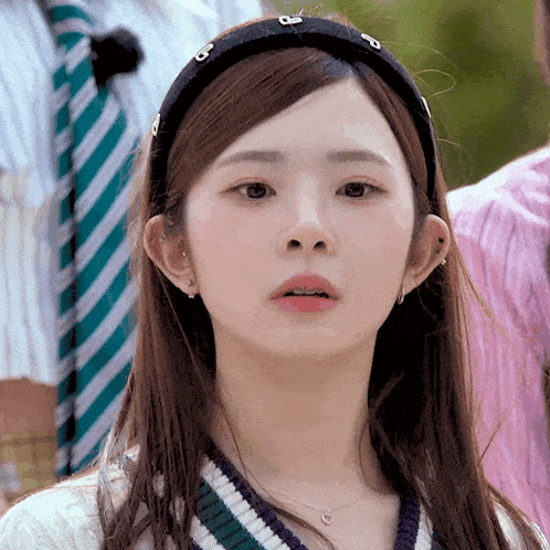 a close up of a woman wearing a headband with the letters o on it
