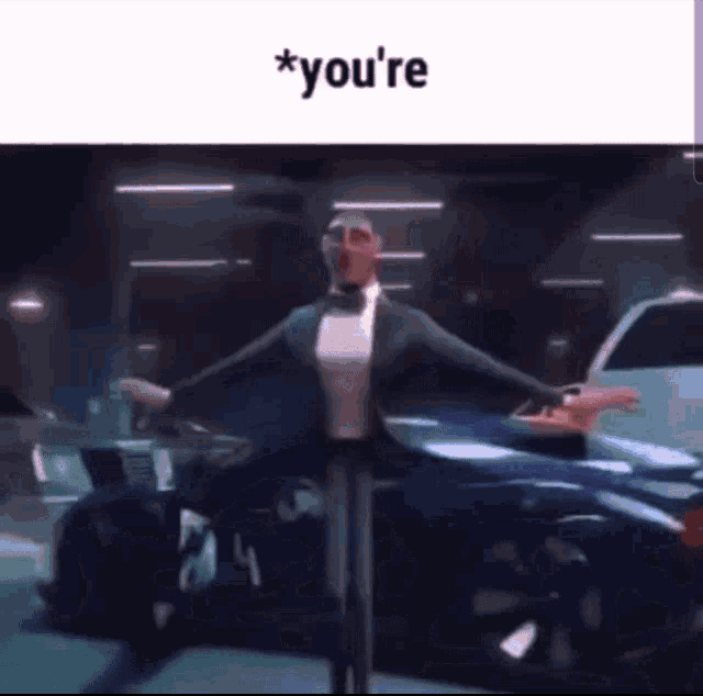 a man in a tuxedo is dancing in front of a car with the words `` you 're '' written above him .