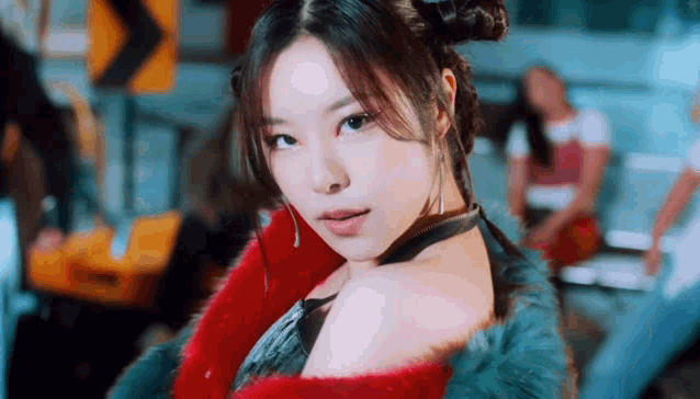 a close up of a woman 's face wearing a fur coat and earrings .
