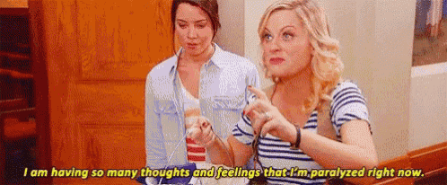 two women are sitting next to each other in a room and talking .