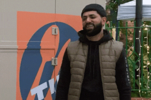a man with a beard is standing in front of a sign that says tn