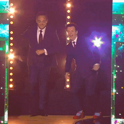 two men in suits and ties are dancing in front of a star