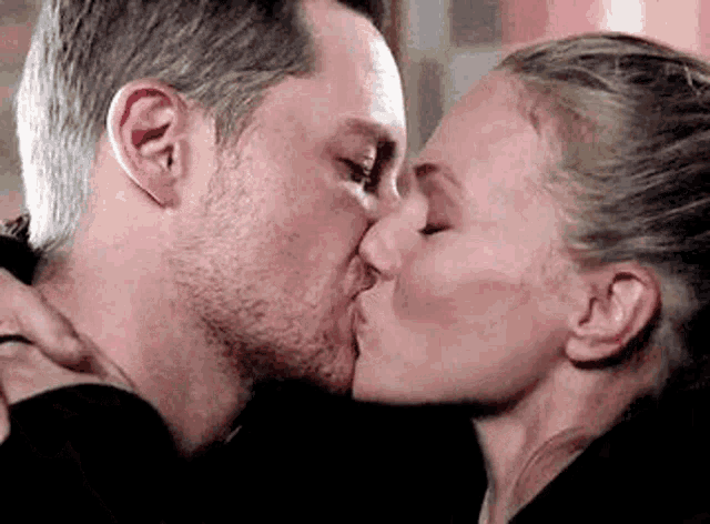 a man and a woman are kissing each other in a close up .