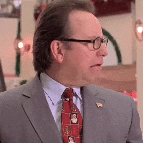 a man in a suit and tie is wearing glasses and a pin