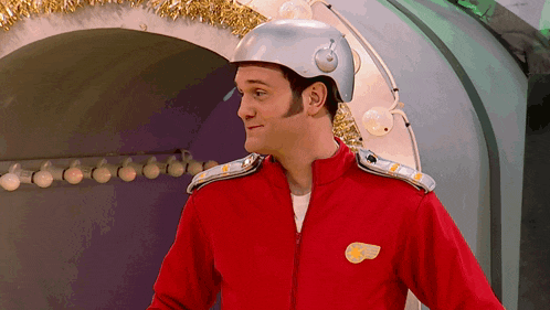 a man wearing a helmet and a red jacket with a yellow badge on his chest