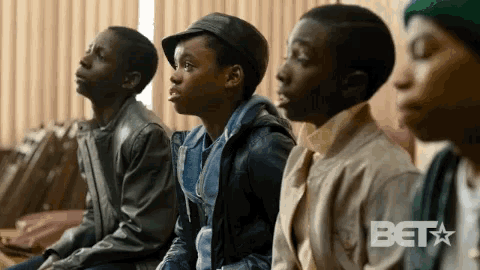 a group of young boys are sitting in a row with the word beta on the bottom right