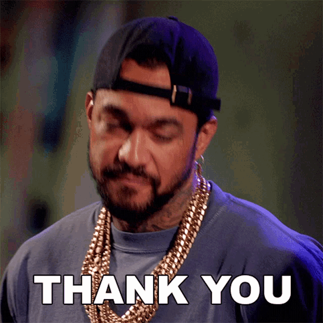 a man with a beard wearing a hat and necklace says thank you