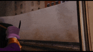 a person in purple gloves is holding a knife in front of a wall