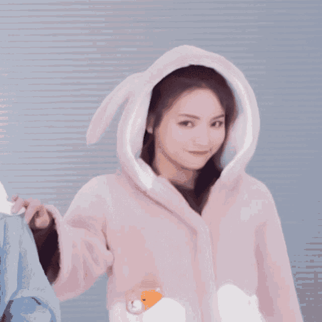 a woman wearing a pink bunny hooded coat
