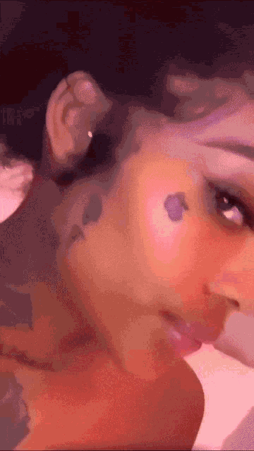 a close up of a woman 's face with a tattoo on her forehead