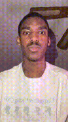 a man wearing a white t-shirt that says ' all together ' on it looks at the camera