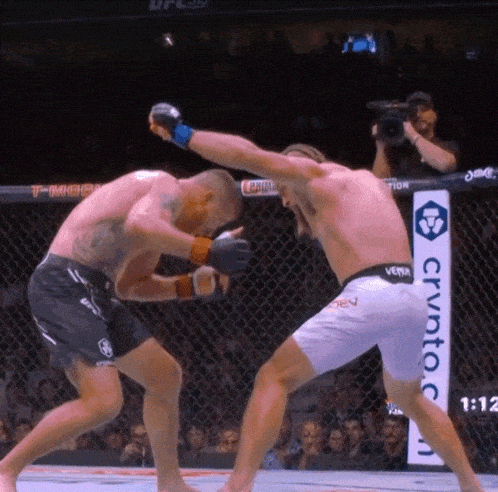 two men are fighting in a ring with a sign that says crypto on it