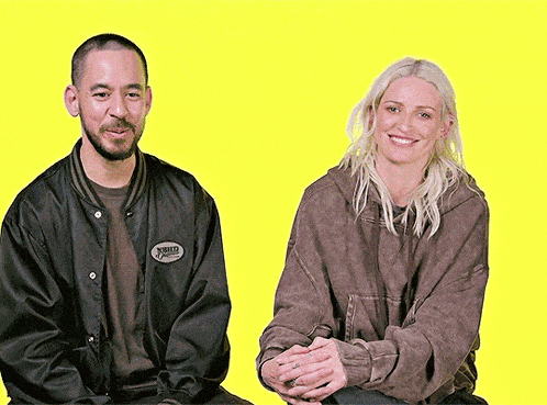 a man and a woman are sitting next to each other and the man is wearing a jacket that says world famous on it