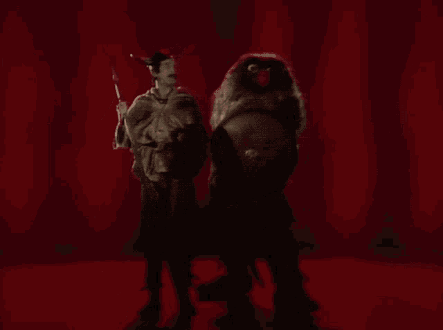 a man in a costume is standing next to a large animal