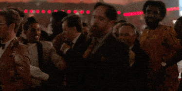 a crowd of people dancing in a dark room with red lights