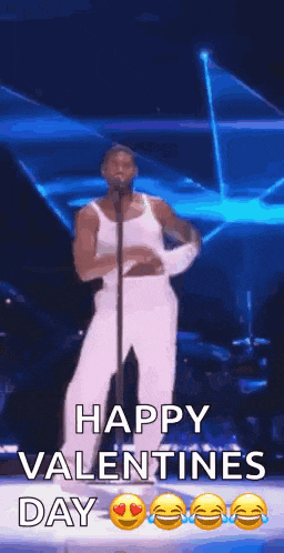 a man is singing into a microphone while dancing on a stage and saying happy valentine 's day .