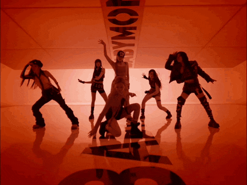 a group of young women are dancing in front of a sign that says abymor