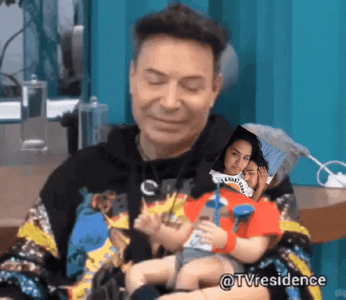 a man is holding a doll with a picture of a woman behind him and the words @tvresidence on the bottom