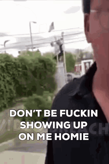 a man in a black shirt says " don 't be fuckin showing up on me homie "