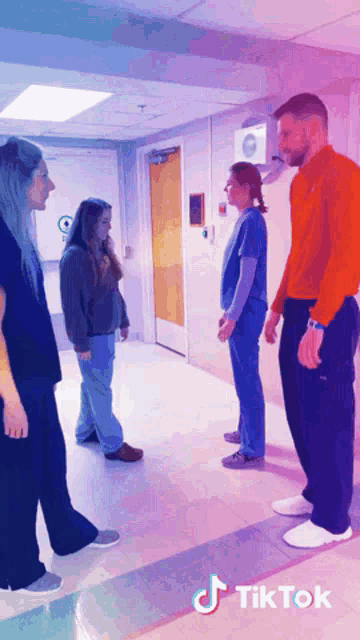 a group of people standing in a hallway with tiktok written on the bottom right
