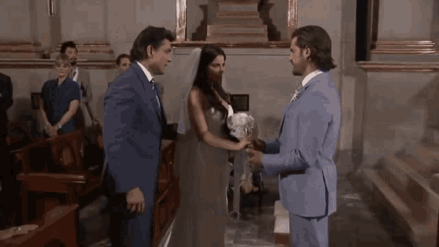 a bride and groom hold hands during their wedding ceremony