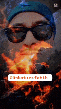 a man wearing sunglasses and a blue beanie is surrounded by fire