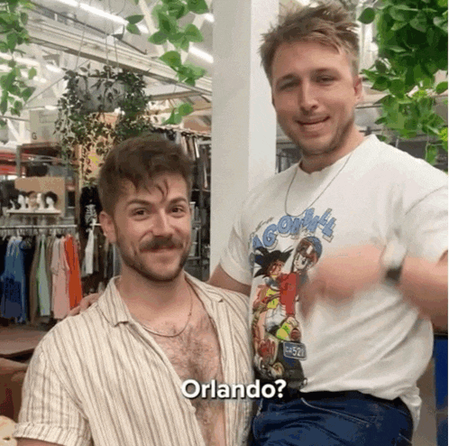 two men are posing for a picture and one has the word orlando on his shirt
