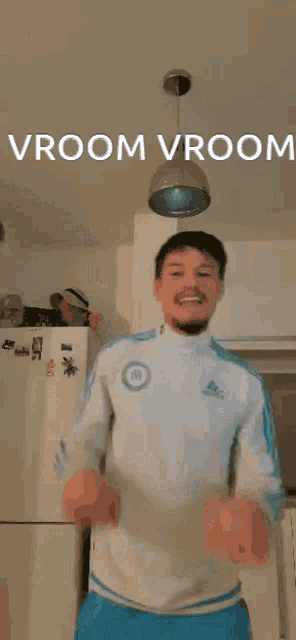 a man is dancing in a kitchen with the words vroom vroom above him .