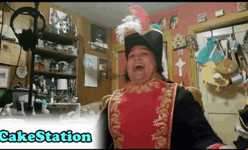 a man in a pirate costume is standing in front of a microphone with the words cakestation above him