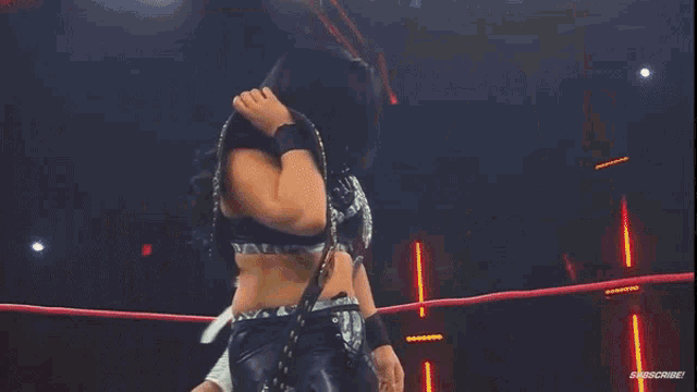 a woman with red hair is standing next to a man in a wrestling ring that says impact on it