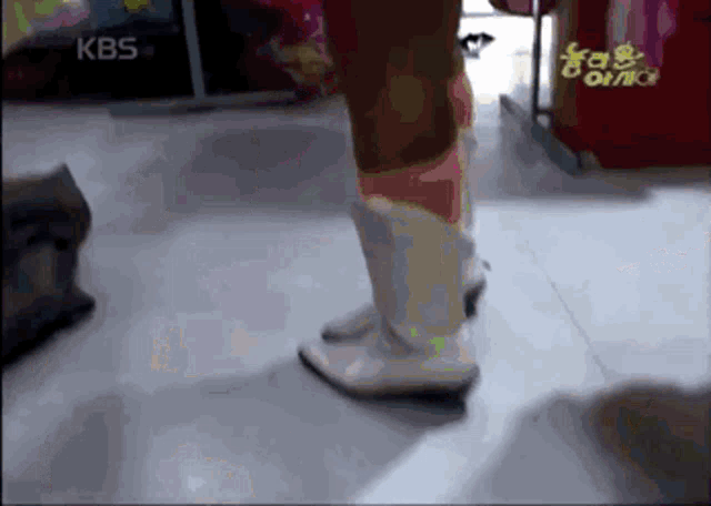 a blurry picture of a person wearing white boots with kbs written on the bottom