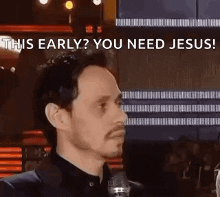 a man in a suit and tie is talking into a microphone and says `` this early ? you need jesus ! ''