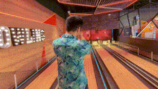 a man is playing bowling in a bowling alley with the word bowling on the wall behind him