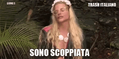 a blonde woman wearing glasses and a flower crown is standing in the jungle and says sono scoppiata .