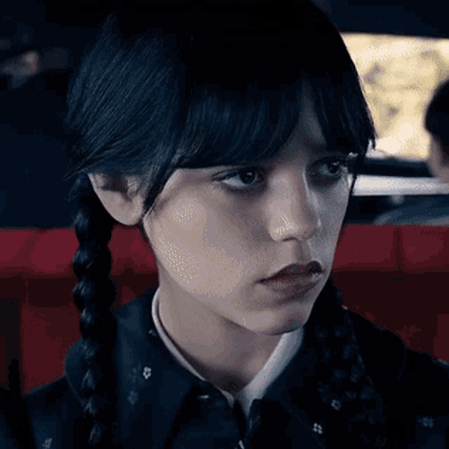 a close up of a woman 's face with braids in her hair