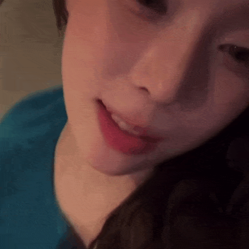 a close up of a woman 's face with red lipstick on her lips .