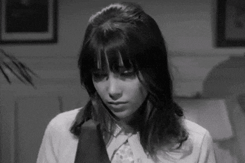 a black and white photo of a woman in a suit and tie .
