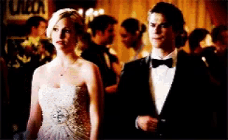 a man in a tuxedo and a woman in a strapless dress stand next to each other