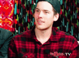 a man wearing a plaid shirt and a hat with spike tv on the front
