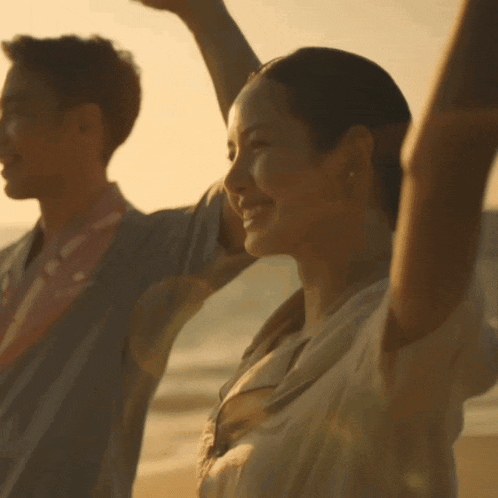 a man and woman with their arms in the air
